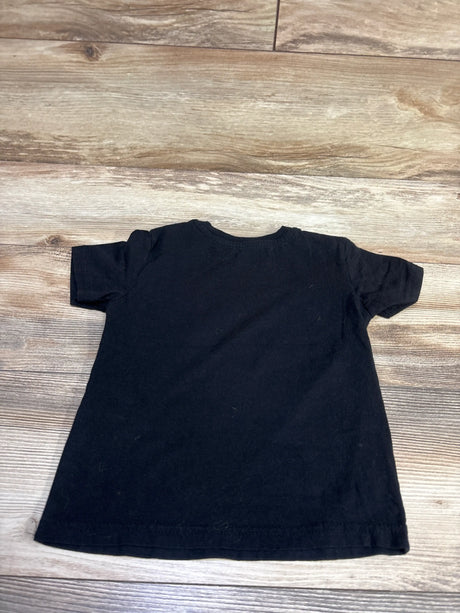 Flat lay of a black short-sleeve Star Wars shirt on a wood-grain background