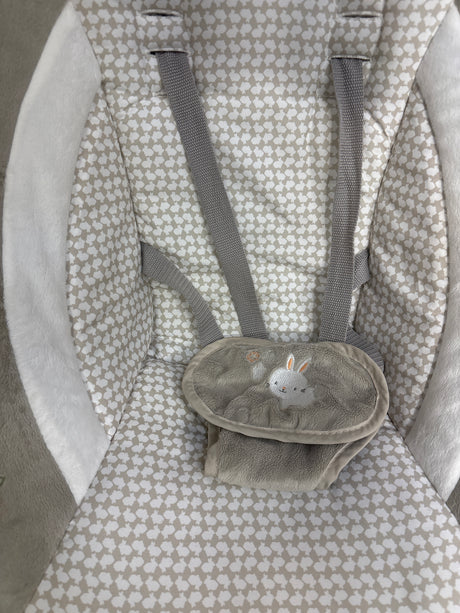 Top-down view of Ingenuity InLighten Cradling Swing seat showcasing gray harness straps, plush beige patterned fabric, and embroidered bunny crotch cover