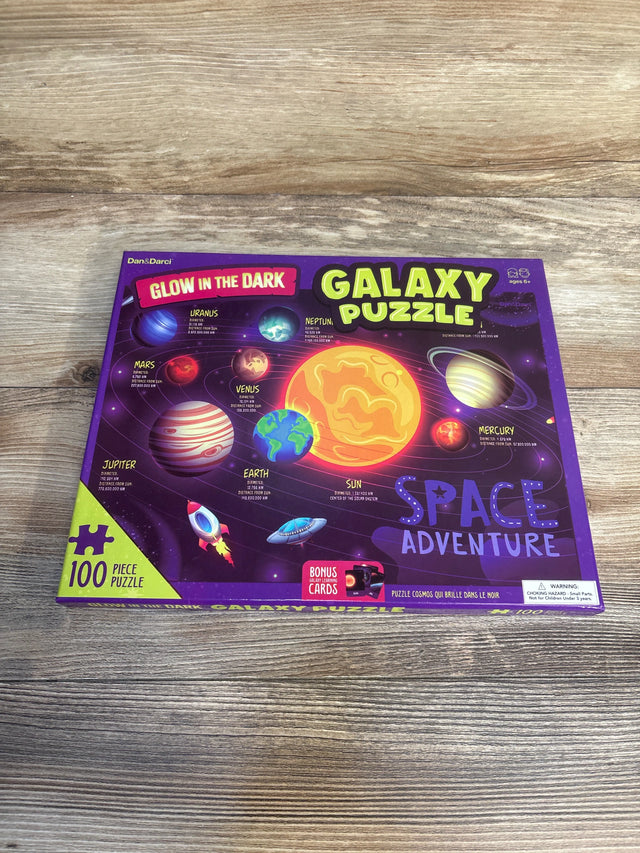 Glow in the dark galaxy puzzle box for kids, 100 piece space adventure with planets illustration.