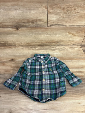 Green plaid baby button-down shirt with long sleeves on wood floor