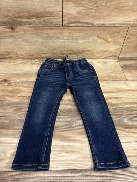 Front view of Cat & Jack drawstring skinny jeans in blue, showcasing the elastic drawstring waist on a wood floor
