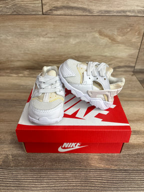 Front three quarter view of Nike Air Huarache Run TD toddler white sneakers showing mesh and leather upper, heel strap on red Nike box