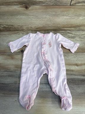 Pink baby onesie with floral embroidery and ruffled details on wooden floor