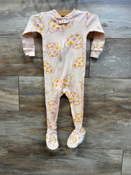 Front view of Carter’s peach footed sleeper showcasing ladybug print and front zipper on a wood floor
