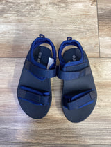 Top view of Old Navy navy toddler double-strap sandals size 8C showing adjustable Velcro straps on wood floor
