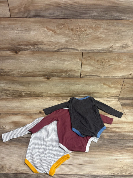 Top-down view of Harry Potter three pack long sleeve bodysuits in black, burgundy, and gray stripes on a wood surface