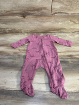 Flat lay of purple footed baby sleeper (9 months) showing front zipper and all-over bow print on wood floor