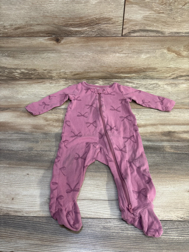 Flat lay of purple footed baby sleeper (9 months) showing front zipper and all-over bow print on wood floor