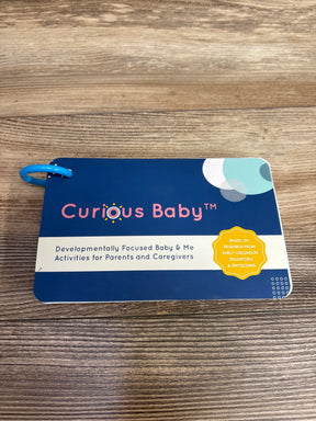 Curious Baby activity card set for baby and parent development, on wood background
