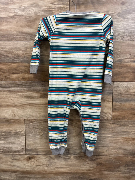Back view of Tea Collection green striped knee patch coverall with gray cuffs and feet on a wood background