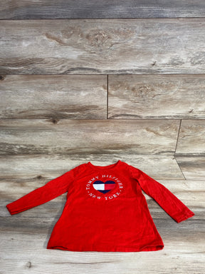 Red long sleeve toddler shirt with Tommy Hilfiger New York heart logo on wood background