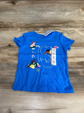 Flat lay of Cat & Jack blue 2T toddler T-shirt showcasing outline dinosaur graphic and colorful children illustrations on wood background