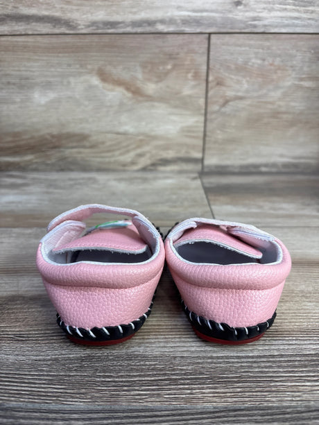 Rear view of pink toddler PU leather sneakers size 3C showing hard black sole with red tread and Velcro strap on wood floor