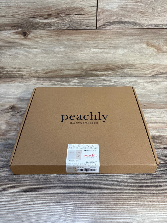 Peachly baby memory book in olive, beautiful baby goods packaging on wood floor