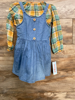 Girls long sleeve plaid shirt with yellow and green tones, layered under blue denim dress with wooden buttons