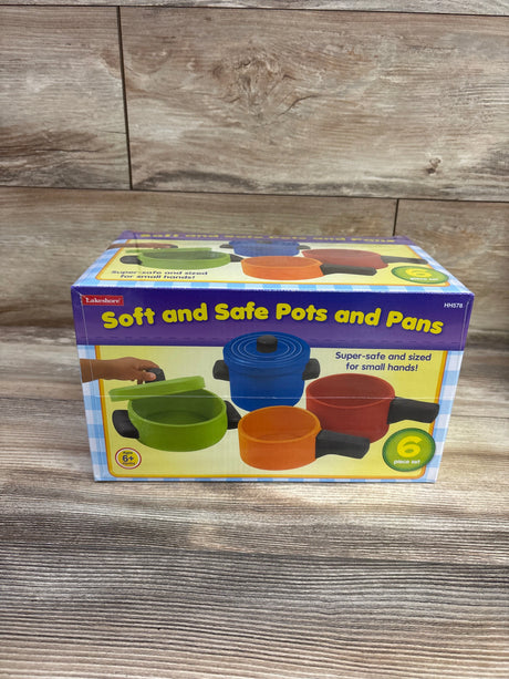 Front view of Lakeshore Soft and Safe Pots and Pans six-piece set in colorful packaging on a wood surface