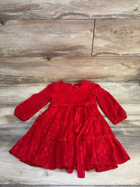 Red long sleeve toddler dress with ruffle skirt and gold accents on wood background