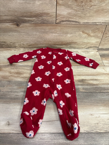 Top-down view of Carter’s red blanket sleeper showcasing pink and white flower print, front zipper, and footed legs on wood flooring