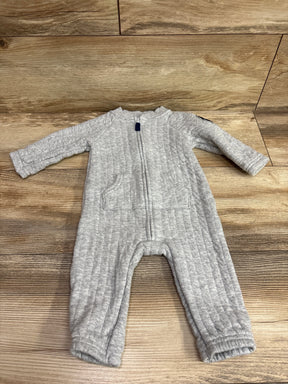Front view of Carter’s grey quilted coverall in size 6 months showcasing a front zipper and two pockets on wood