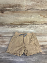 Front view of tan Cat and Jack drawstring shorts with elastic waistband, braided drawstring, and front pockets on wood floor
