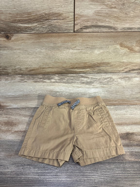 Front view of tan Cat and Jack drawstring shorts with elastic waistband, braided drawstring, and front pockets on wood floor