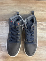 Pair of dark gray high-top kids sneakers with navy laces on wooden floor