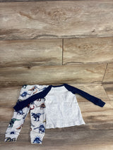 Top view of toddler dinosaur 2-piece pajamas: grey raglan top with navy sleeves and grey dinosaur-print pants on wood floor