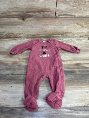 Pink fleece baby onesie with footies and zipper, embroidered with 'The Future Is Ours' on front, laid on wooden floor
