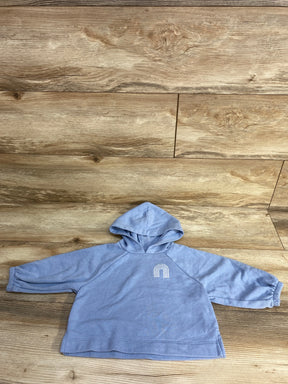 Light blue toddler hoodie with white rainbow embroidery on wooden floor background