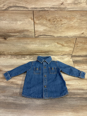 Front view of Carter's blue denim baby jacket showing button front, two chest pockets and point collar on wood background