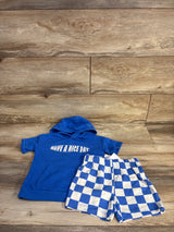 Top-down view of blue toddler hooded tee reading HAVE A NICE DAY with blue-and-white checkered shorts on wood background