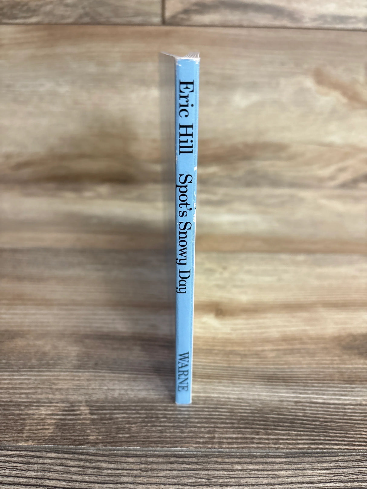 Spine of children's book Spot's Snowy Day by Eric Hill on wood surface