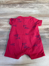 Back view of Carter's newborn shortie romper showing short sleeves and navy pennant print on red fabric, laid flat on wood background