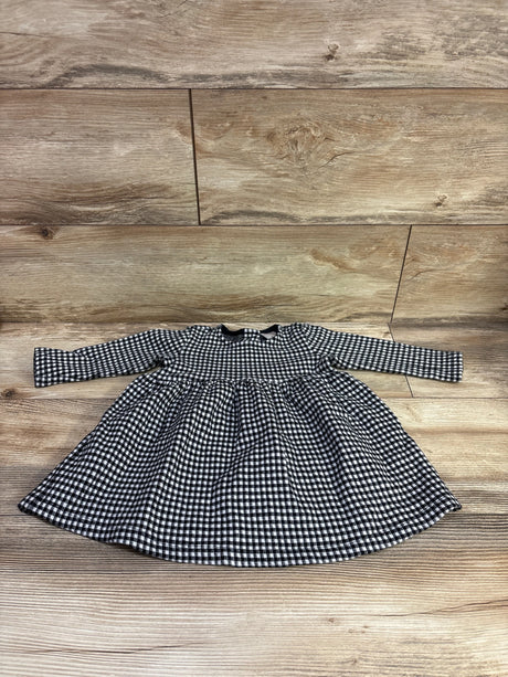 Front view of Hanna Andersson long sleeve gingham dress in size 12 to 18 months showcasing gathered waist and flared skirt on a wood floor