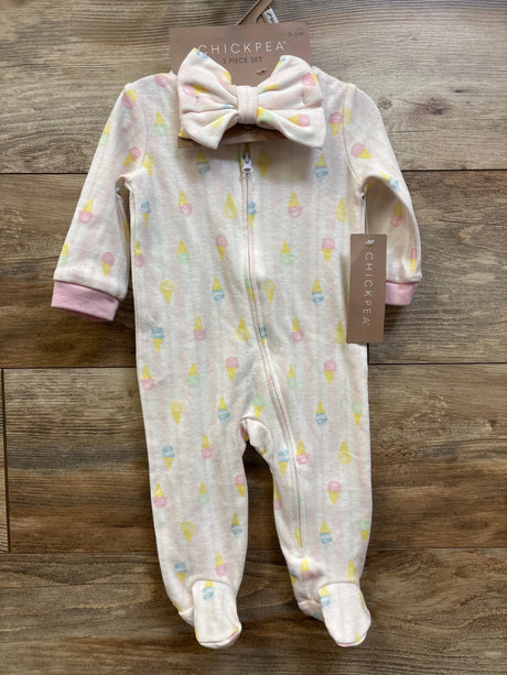 Front view of pink Chick Pea sleeper and headband set showcasing pastel ice cream print and zipper on wood background