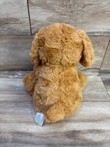 Rear view of Cloud Island brown dog plush showcasing soft curly fur, floppy ears, and small tail with wood plank background