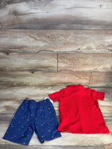 Red toddler polo shirt and navy shark-print shorts on wood floor, kids clothing set