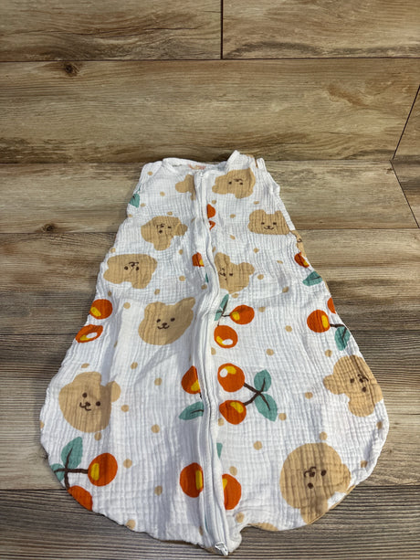 Top-down view of white gauze baby sleep sack (small 0-6m) with front zipper, bear face and orange fruit print laid on wood surface