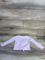 Back of pink Nike toddler long-sleeve shirt size 4T with tied hem and black swoosh on sleeve on wood background