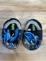 Kids' black Batman slippers with cartoon graphics on wood background