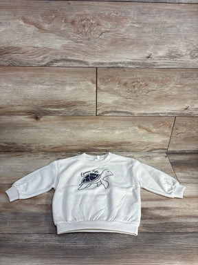 White toddler sweatshirt with black turtle illustration and Ocean Life text on wooden floor