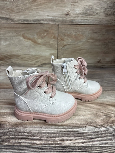 Front view of Cat & Jack Amaya combat boots showcasing ivory uppers and pink laces with a wood-grain background