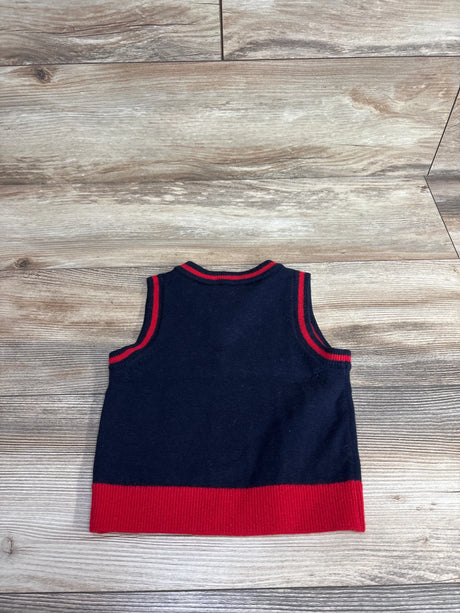 Navy blue and red sleeveless toddler sweater vest laid flat on wooden floor
