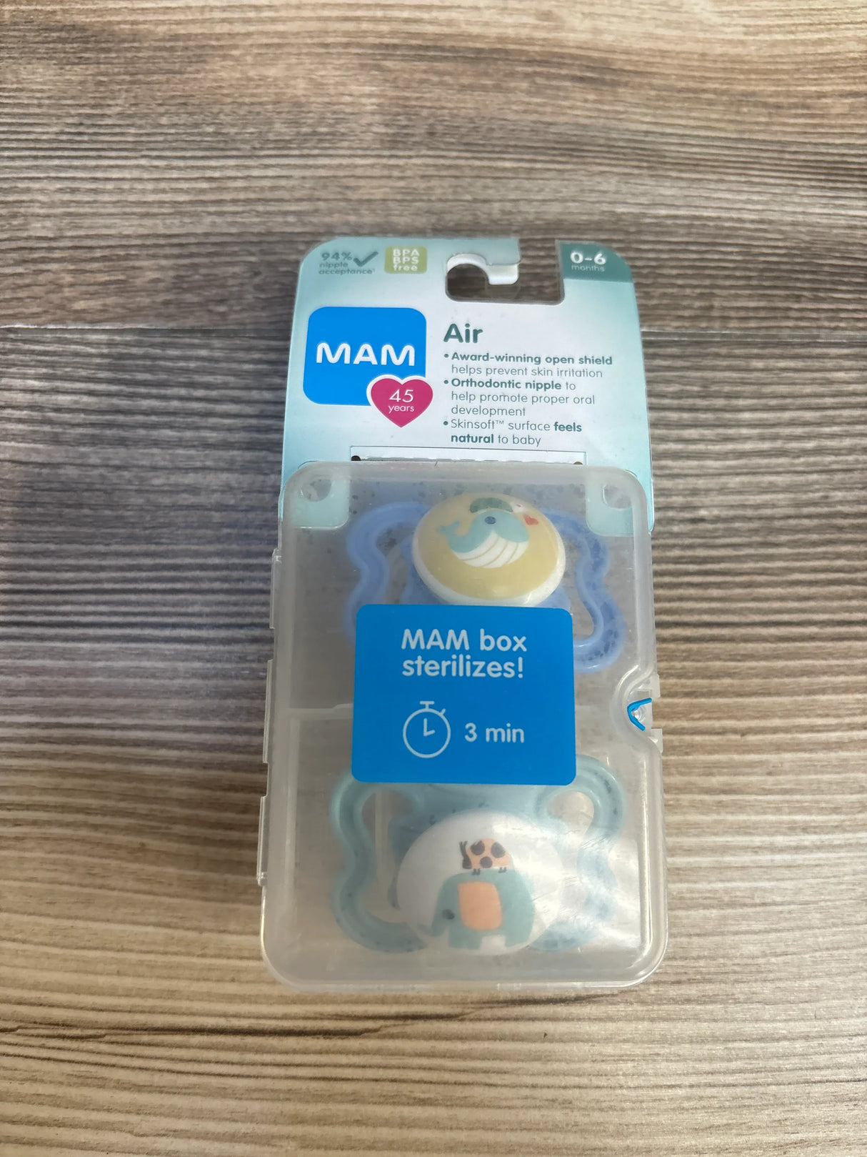 MAM Air baby pacifiers 0-6 months in sterilizing case on wood surface, BPA free, cute animal designs