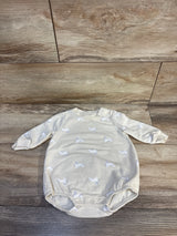 Cream baby bodysuit with bunny print and long sleeves on wood floor