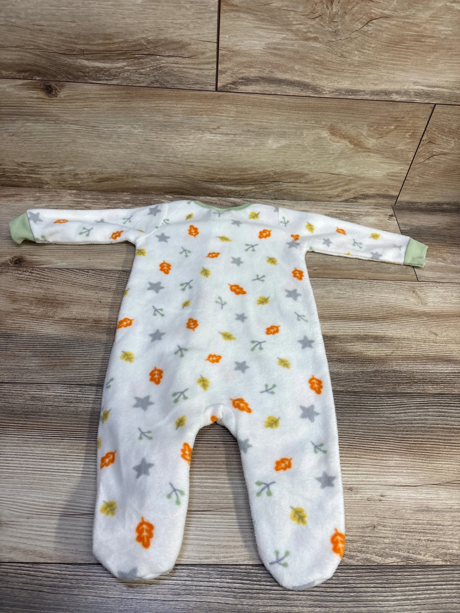 Flat lay of Koala baby blanket sleeper, white size 3-6m, with long sleeves, footed legs, and colorful leaf and star pattern