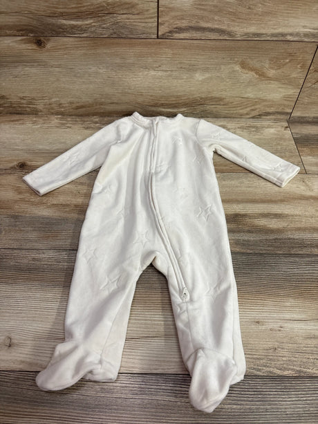 Front view of Old Navy ivory velour sleeper with star pattern, front zipper, and attached feet on wood