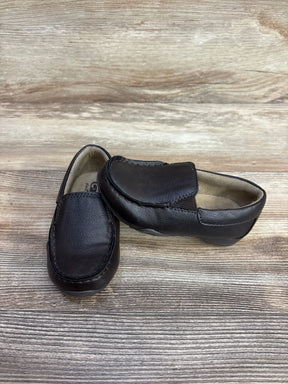 Angled view of Children's Place brown slip-on shoes size 8C showing leather texture and moc-toe stitching on wood background