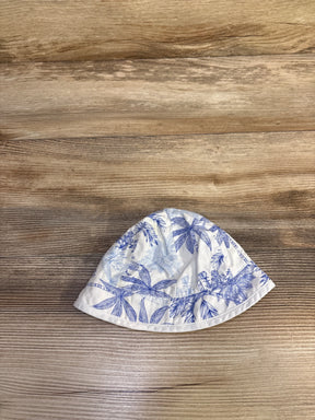 Top-down view of baby bucket hat showcasing blue palm tree print on white cotton, size 0-3 months, on light wood background