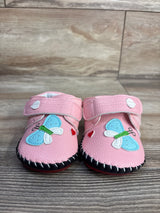 Front view of pink PU leather baby sneakers size 3C showing butterfly and heart appliques and Velcro strap on wood surface